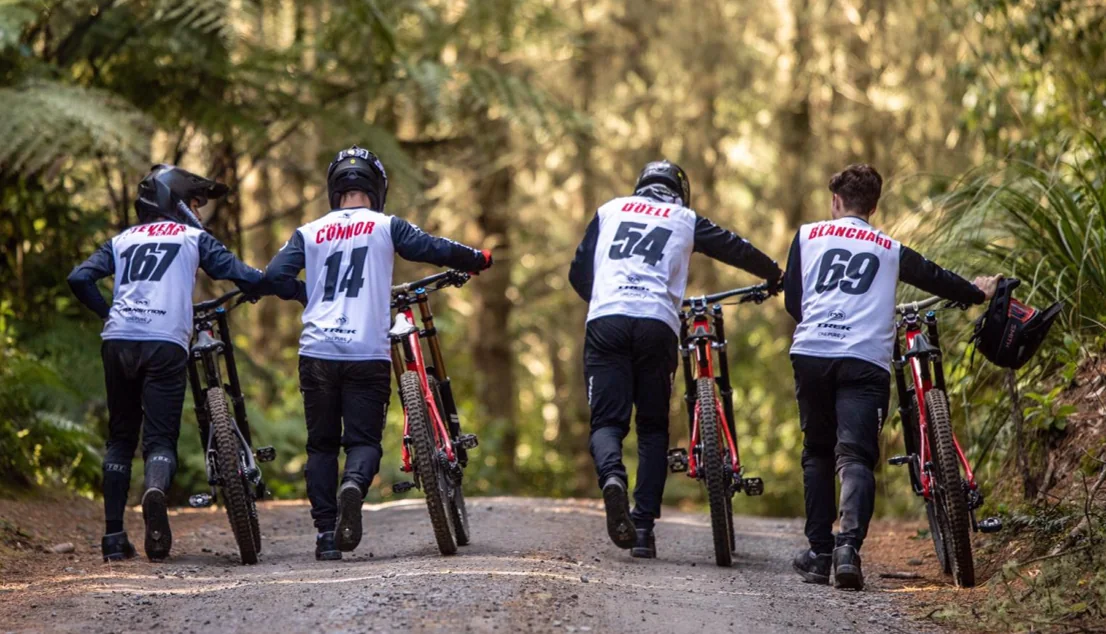 Riders pushing their bikes back up the track